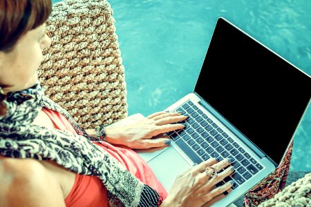 Woman Wearing Pink Top With Macbook On Lap photo