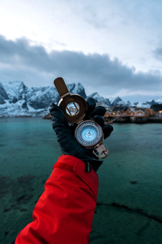 Person Wearing Black Leather Gloves Holding Brass-colored Compass photo