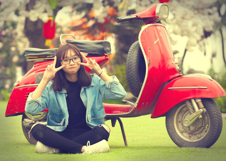 Girl Doing Peace Sign Indian Sitting In Front Of Red Scooter Motorcycle