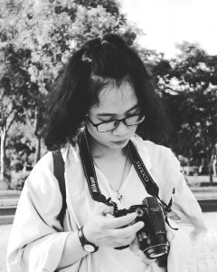 Grayscale Photo Of Woman Holding Black Nikon Coolpix Dslr Camera photo
