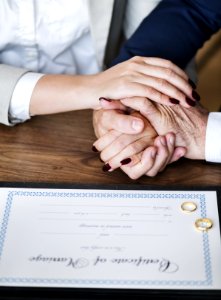 Man And Woman Holding Hands On Brown Wooden Table photo