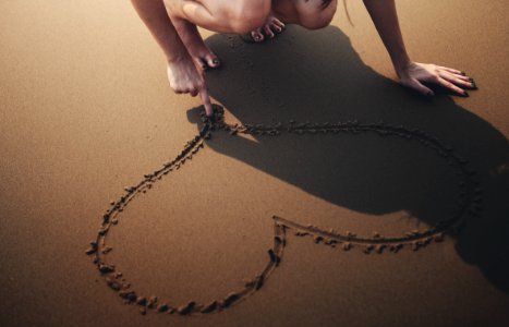 Person Draws Heart On Sand photo
