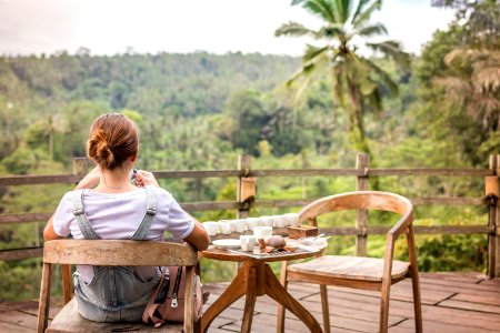 Brown-haired Woman Sitting On Brown Wooden Chair On Patio photo