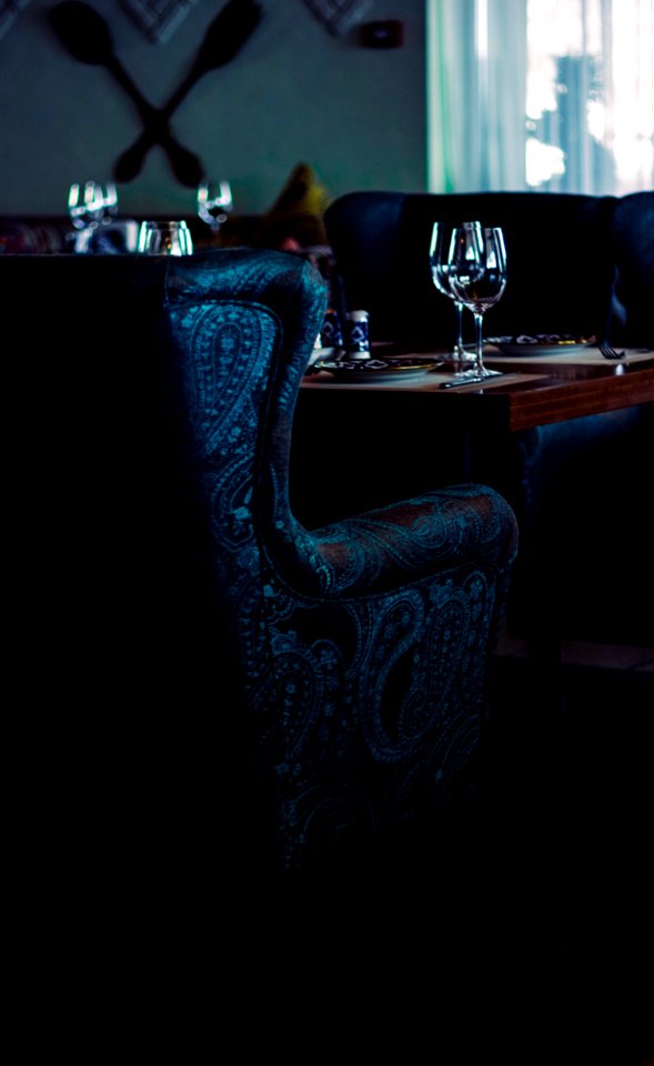 Water Goblets On Brown Wooden Table With Sofa Chairs