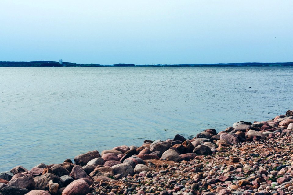 Rock Lot By The Body Of Water Under Blue Sky photo