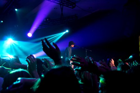 Man Singing On Stage With Stage Lights Near Crowd photo