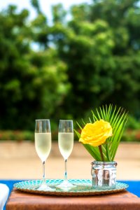 Yellow Rose Flower Centerpiece And Two Clear Champagne Flutes photo