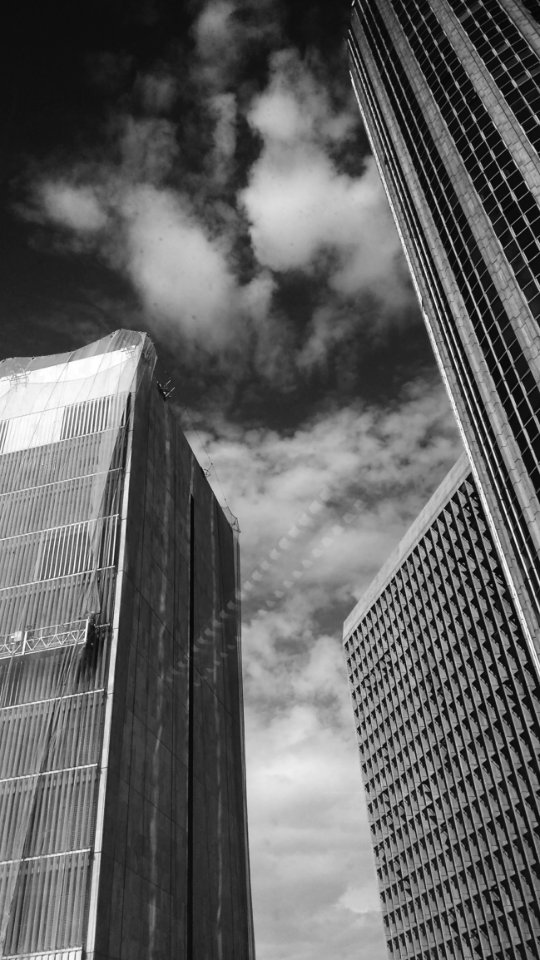 Low Angle Grayscale Photography Of Buildings And Clouds photo