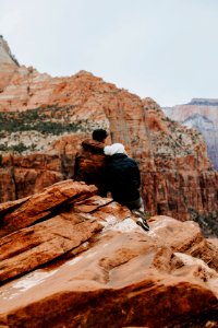 Couple Sitting On Rock Cliff photo