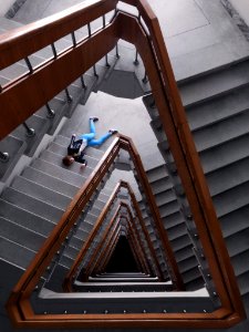 Person In Black Jacket And Blue Denim Pants Laying On Spiral Staircase