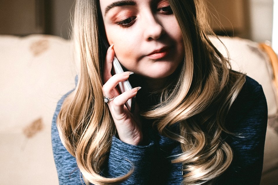 Woman In Gray Top Using Her Mobile Phone