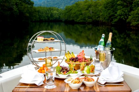 Food Photography Of Food And Wine Bottles On Table Inside Boat