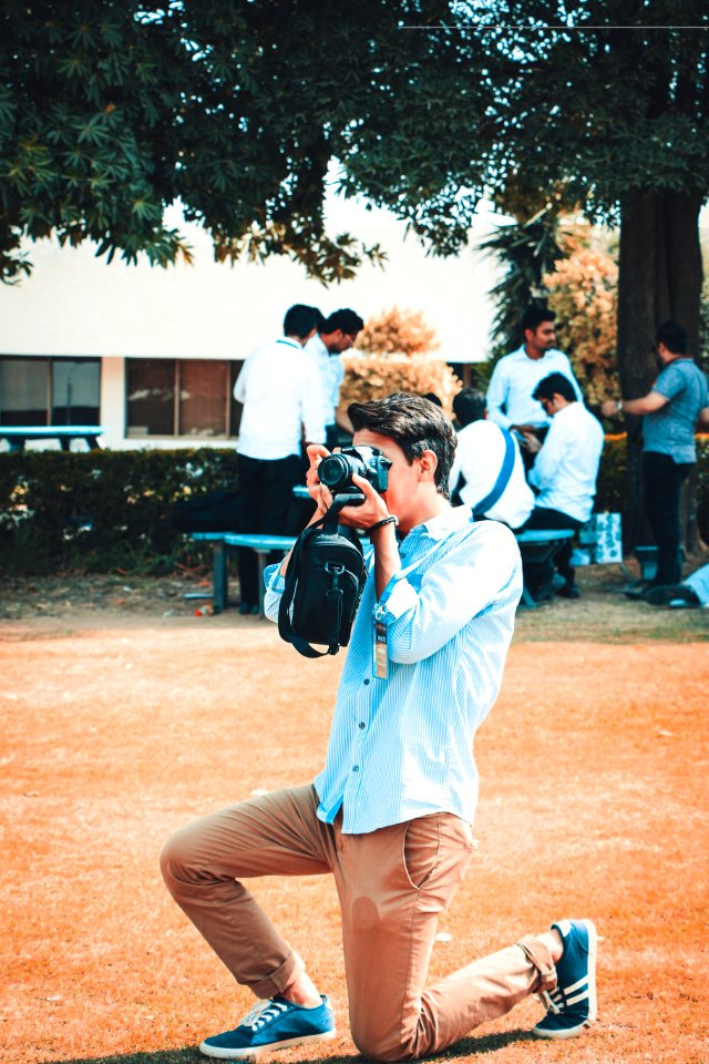 Man Holding A Black Dslr Camera
