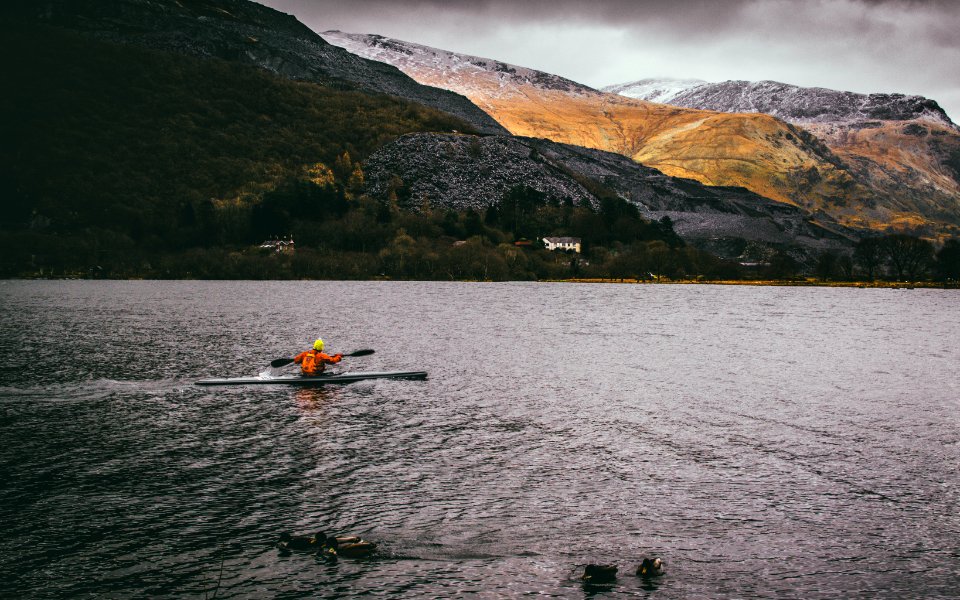 Person Kayaking On Body Of Water