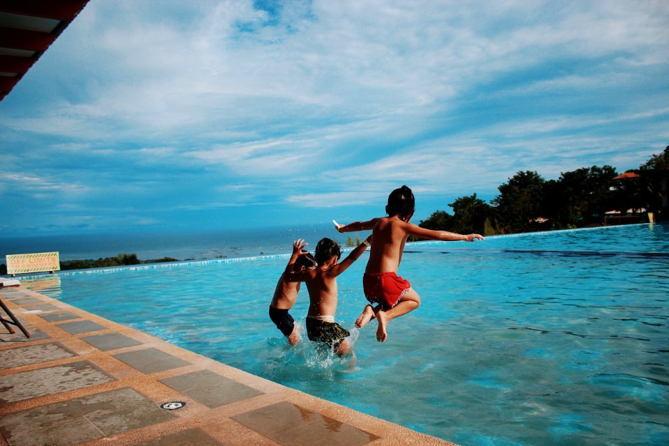 Three Boys Jumping Into The Water