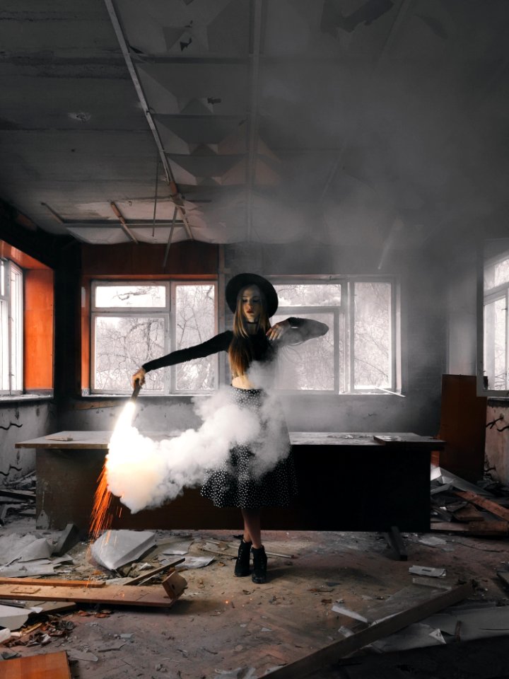 Woman Holding Smoke Flare Standing Front Of Table Inside House