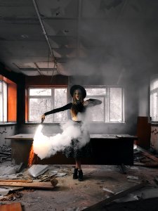Woman Holding Smoke Flare Standing Front Of Table Inside House photo