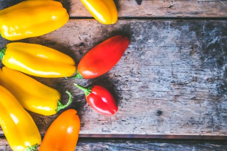 Yellow Orange And Red Peppers On Wooden Surface