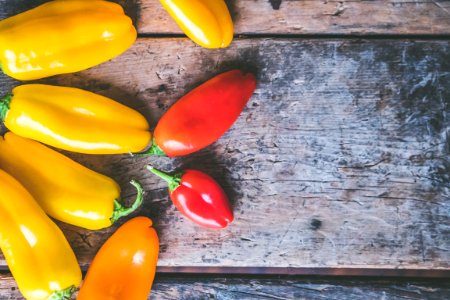 Yellow Orange And Red Peppers On Wooden Surface photo