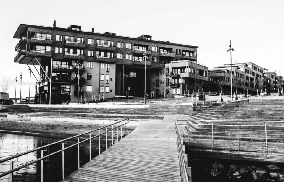 Gray Scale Photo Of A Dock Near A Building photo