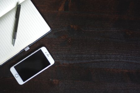 Silver Iphone 6 Beside White Book With Pen photo