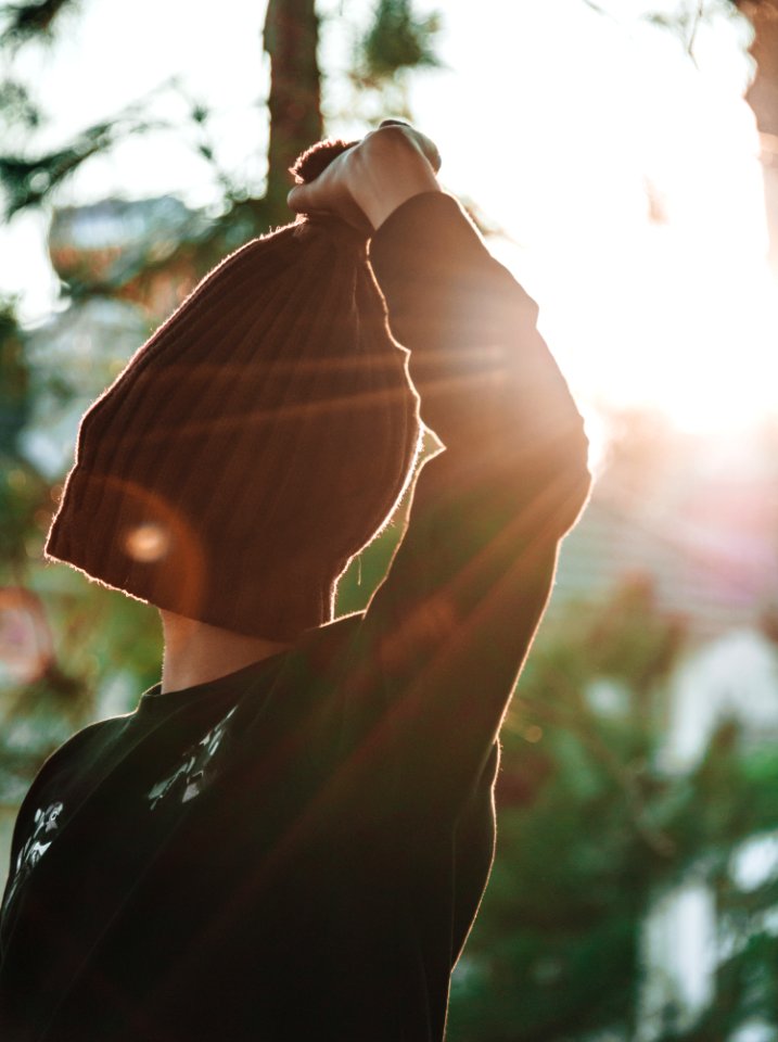 Person Covering Its Face With Knitted Hat