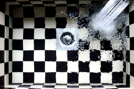 Water Flowing On White And Black Checked Bath Tub photo