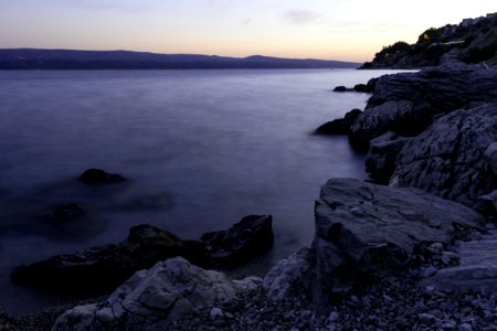 Photo Of Calm Body Of Water Beside Rock Formations photo