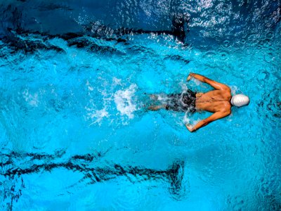 Person Swimming On Body Of Water photo