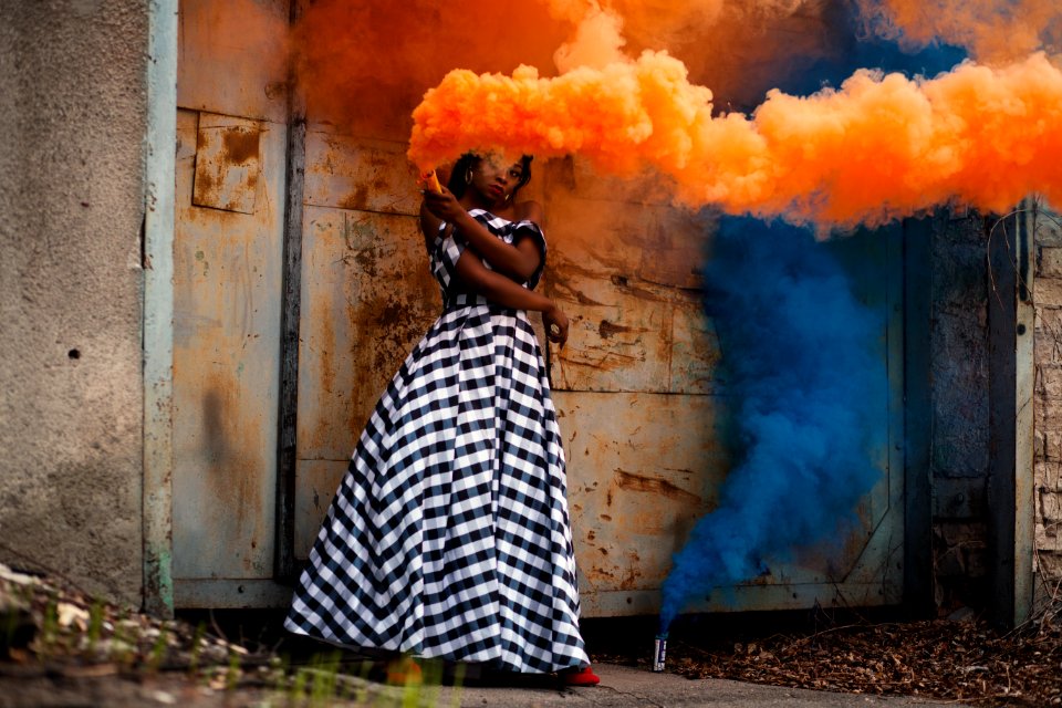 Woman In White And Black Dress Holding Orange Smoke