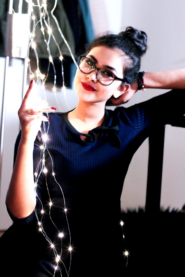 Woman Wearing Black Knit Elbow-sleeved Top Touching Mini String Lights