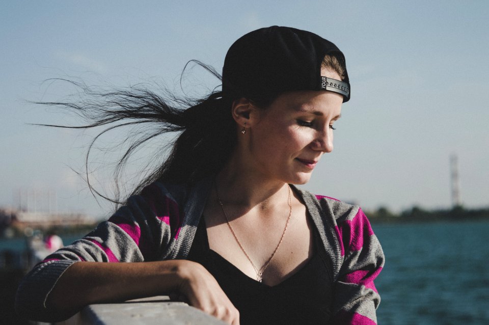 Selective Focus Photography Of Female Wearing Black Snapback Near Ocean
