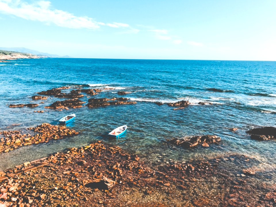 Two Blue Wooden Boats On Ocean Portrait