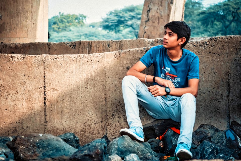 Man Sitting On Stone Leaning On Concrete Wall