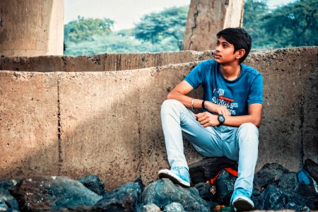 Man Sitting On Stone Leaning On Concrete Wall photo