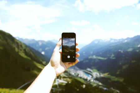 Person Holding Space Gray Iphone 5s Taking Picture Of Mountains photo