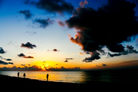 People Standing On Seashore During Sunset photo