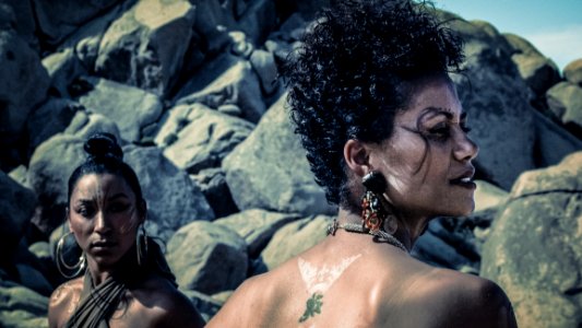 Photo Of Two Women With Tattoos Standing Near Rocks