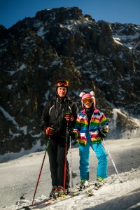 Man And Woman Wearing Snow Ski Suit And Snow Ski With Poles During Snow photo