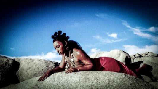 Woman Posing On Top Of Stone Under Blue Sky photo