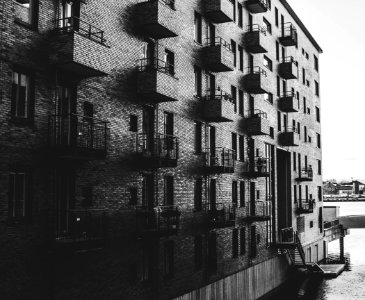 Grayscale Photo Of Building Beside Body Of Water photo