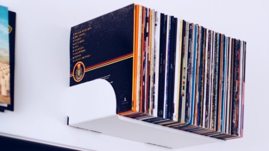 Assorted Book Hanging On White Painted Wall