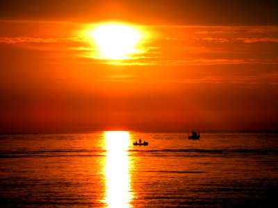 Silhouette Of People On Boat During Golden Hours photo