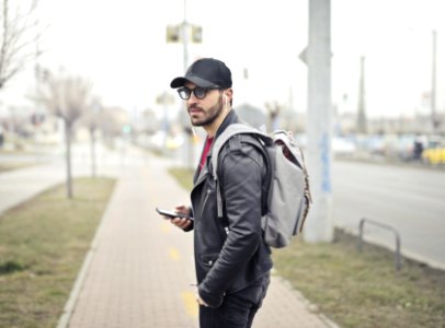 Man Wearing Black Leather Jacket Holding Smartphone photo