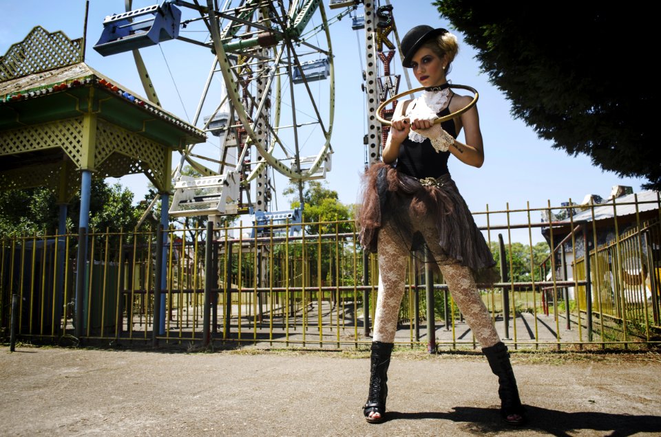 Woman In Black Camisole Top Stands Behind Ferris Wheel
