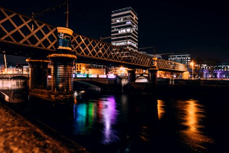 Architectural Photo Of Brown Concrete Bridge And High Rise Building During Night Time photo