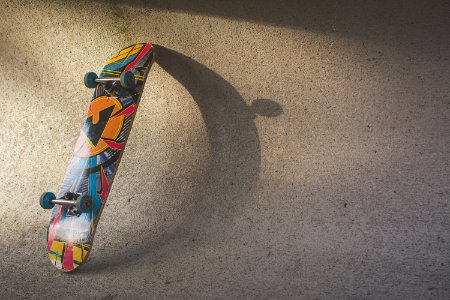 Multicolored Skateboard Leaning On Wall photo