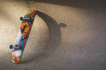 Multicolored Skateboard Leaning On Wall