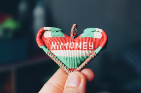 Person Holds Red And Teal Himoney Pendant