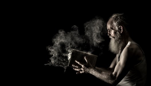 Man In White Tank Top Holding Book photo